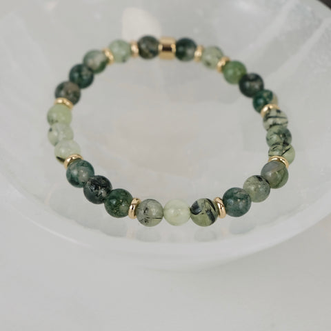 A crystal bracelet in a white selenite bowl