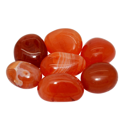A bunch of Carnelian gemstones. They have a bright red appearance and some lighter lines and patterns inside the stone.