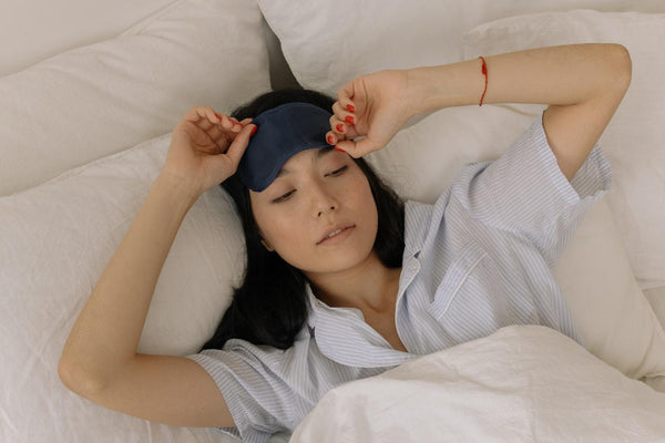 A woman waking up and stretching in her bed