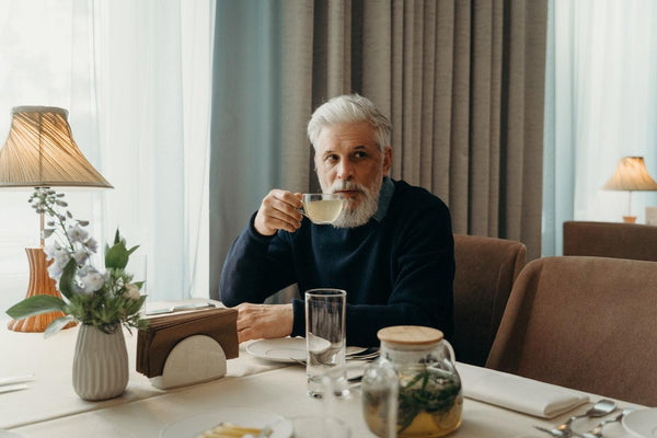 a man drinking a cup of CBD infused tea