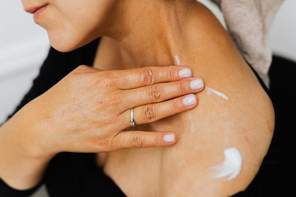 A woman suffering from shoulder pain applying CBD icy hot