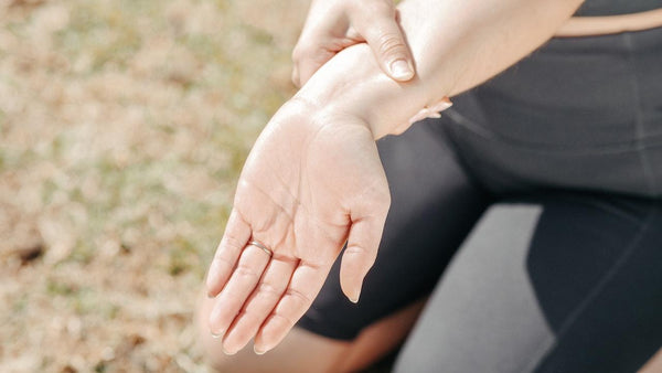 a woman rubbing CBD on her wrist