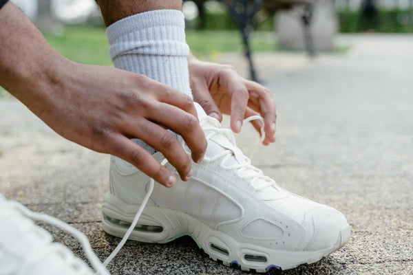 a close up image of a man tying his shoes