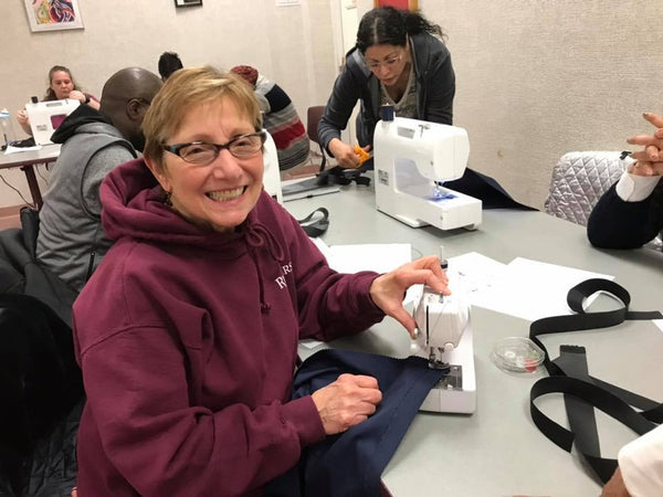 Woman smiling at a sewing machine