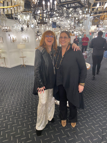 Robin Baron with guest at the lighting showroom underneath many lighting fixtures.