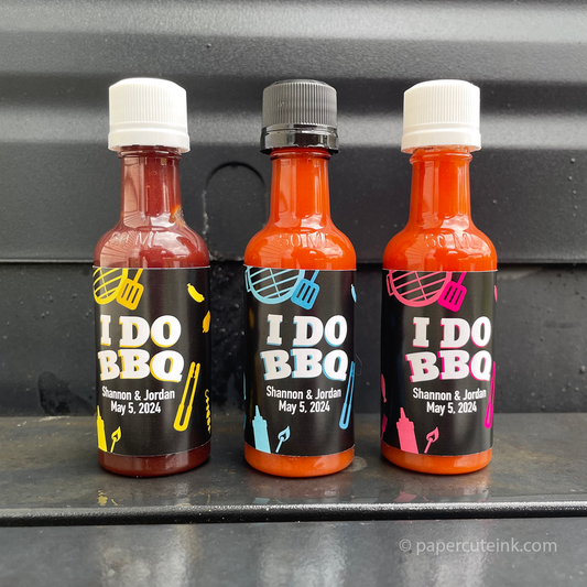 Personalized miniature bbq sauce favor bottles with black label that reads I Do BBQ