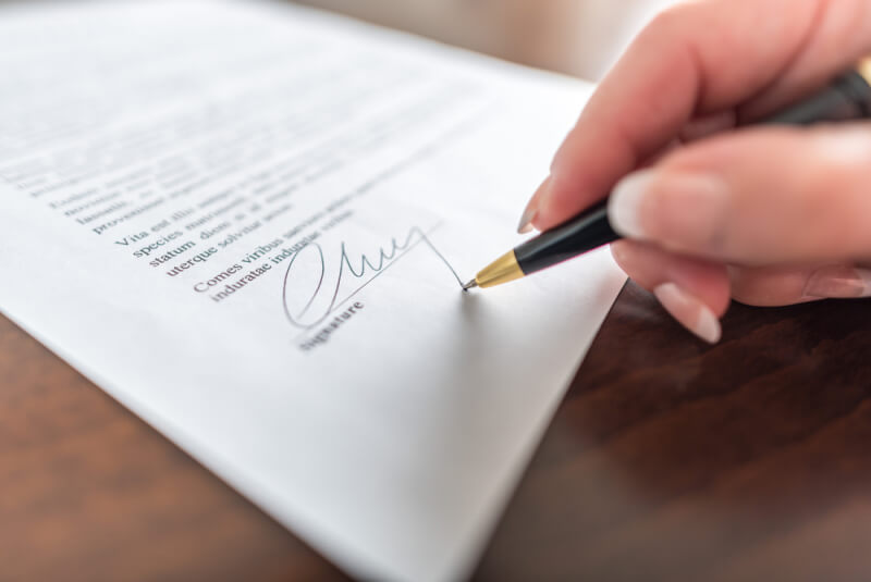 Woman hand signing a contract 