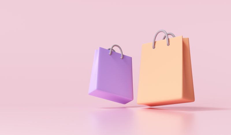 two shopping bags on pink background