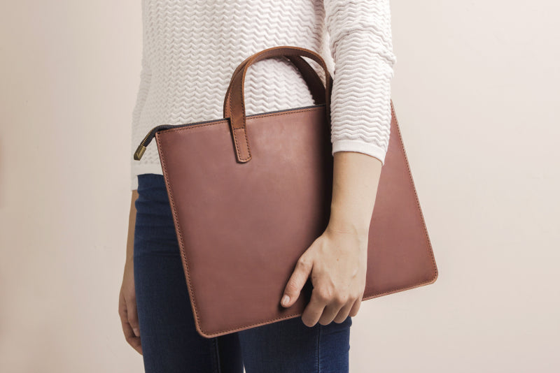 woman holding laptop leather bag