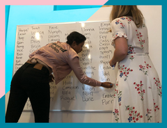 unbound team members writing names on a wipeboard