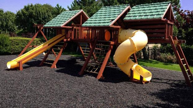 Black Painted Rubber Playground Mulch Under a Swingset 