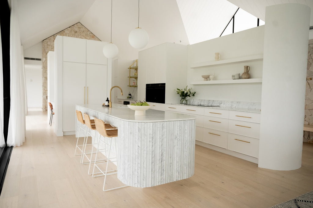 minimalist kitchen design with marble counter top and gold colour handles on cupboards