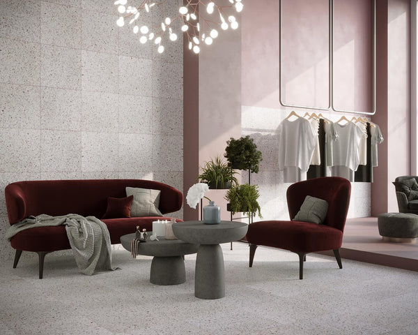 a retail spacious area with red couches and terrazzo tiles flooring and wall tiles.