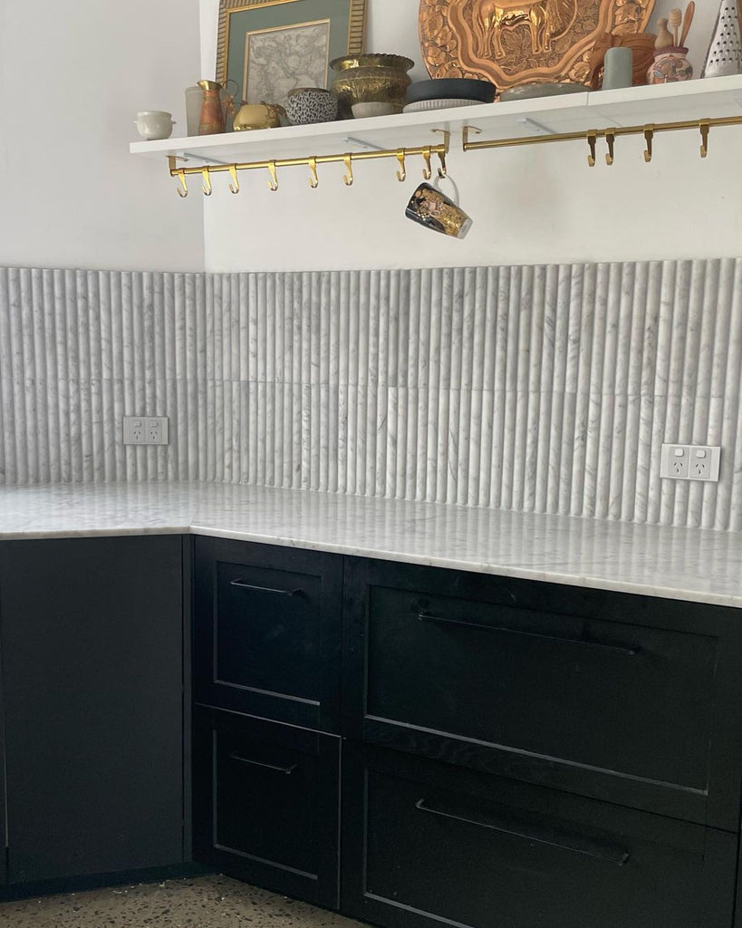 Carrara white marble mosaic kitchen splashback with white Carrara marble countertop and black cupboards