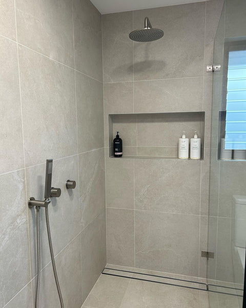 shower area with beige limestone-look porcelain on the walls and floor.