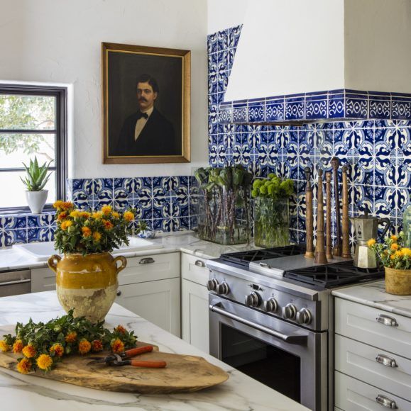 European inspired traditional style kitchen design with blue patterned tiles on the splashback and a marble countertop