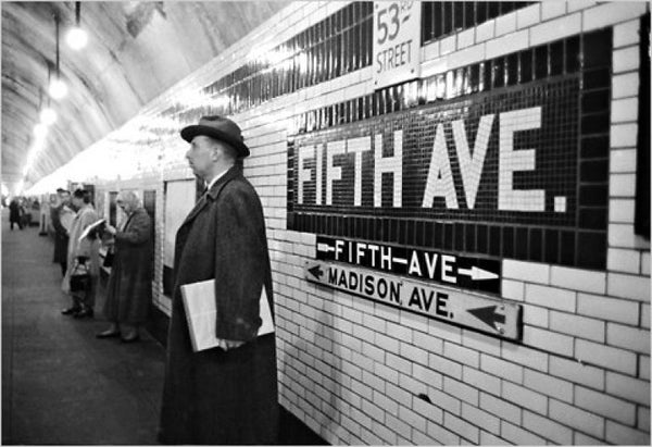 New York subway in the early 20th century. There is a man wearing black coat and hat