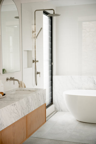 a bathroom design with grey porcelain flooring and white tiles on the walls.