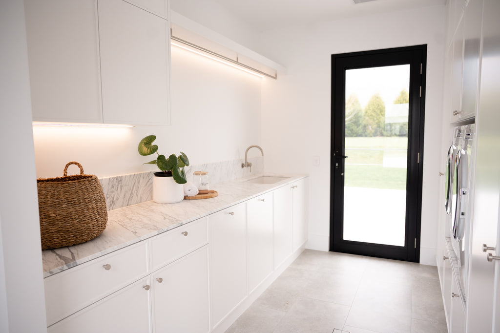 a laundry room with white marble tiles on the walls and grey porcelain tiles flooring