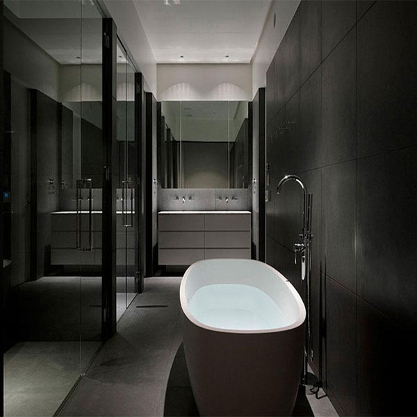 A bathroom with all black design. There are some white features for contrast. Black colour natural stone is used for the flooring and the walls. 