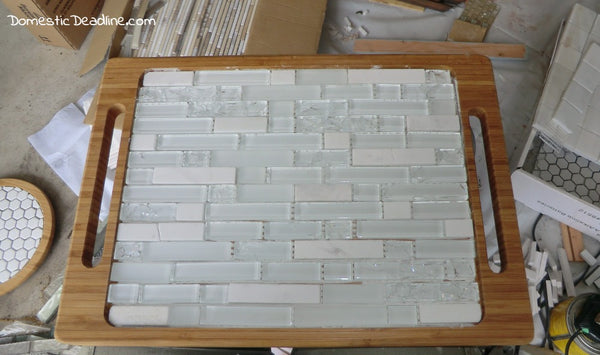 a stone mosaic tray with brown handles