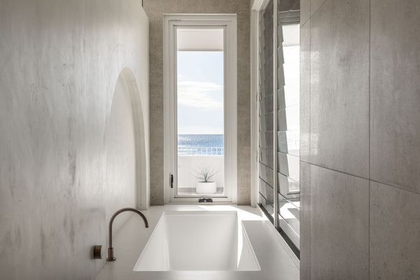 bathroom with bathtub and limestone-look porcelain with large tiles on the walls and floor