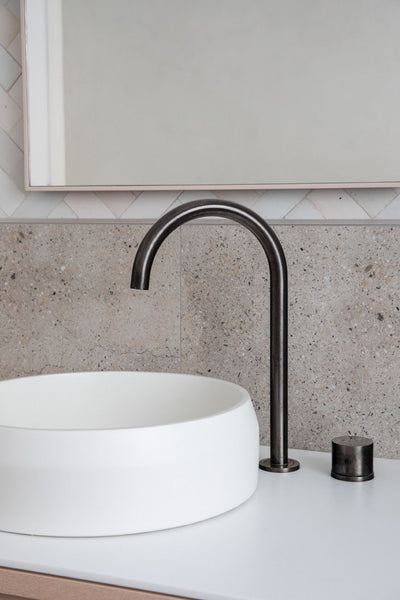 white basin in minimalist bathroom with beige wall tiles