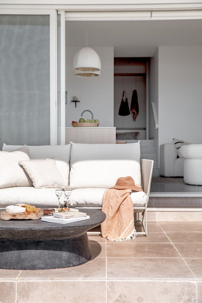 beach home outdoor with light pink marble tiles on the floor and a couch and few chairs