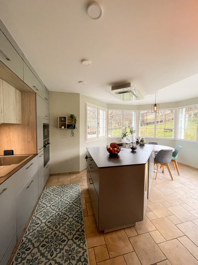 cosy looking kitchen with large windows at the far end