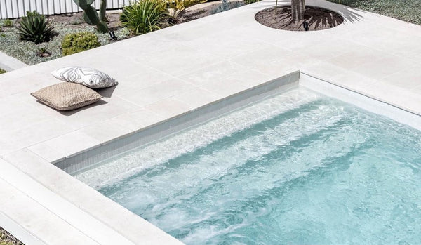outdoor pool area with beige marble paver