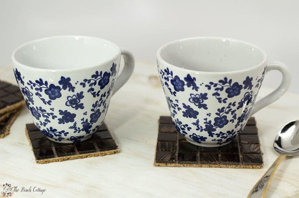 two white and blue cups on coasters 