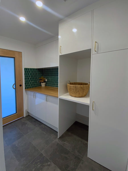 a storage area in a bathroom with white cupboards and grey porcelain tiles flooring