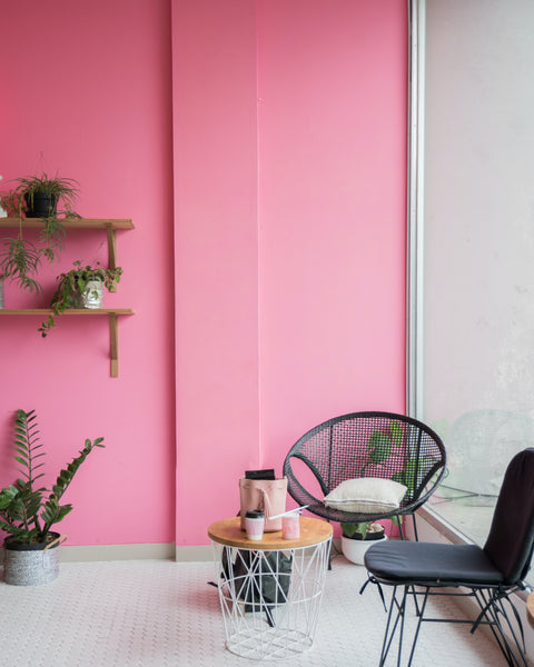 modern style interior space next to a balcony with a pink wall and two chairs.