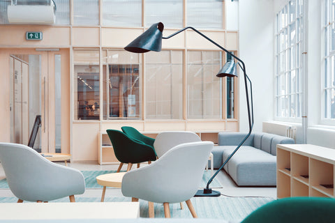 spacious room with light brown sofas and chairs and big windows