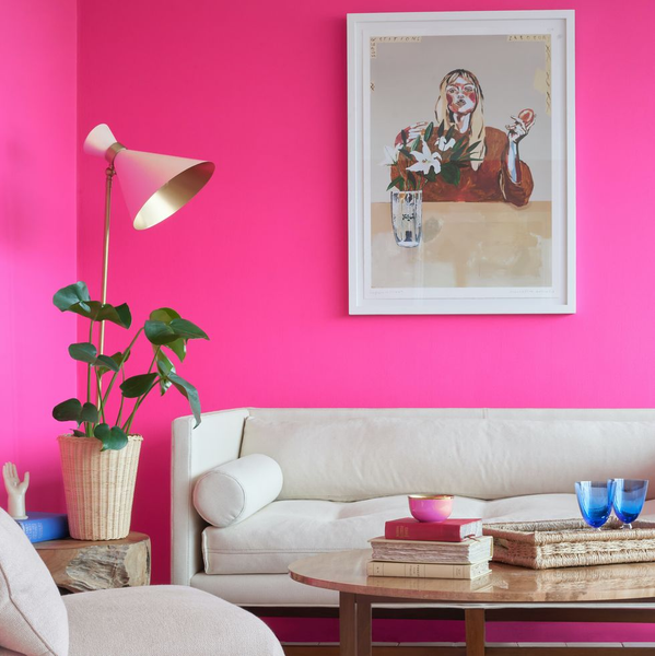 A living room with pink walls and white sofa