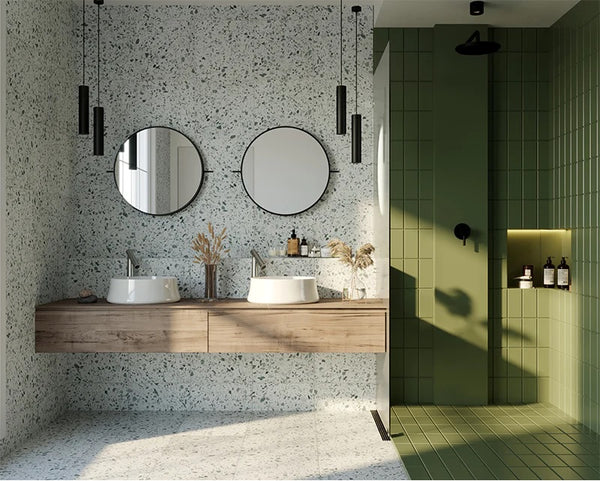 bathroom with green and grey terrazzo tiles and green tiles on one side where the shower is.