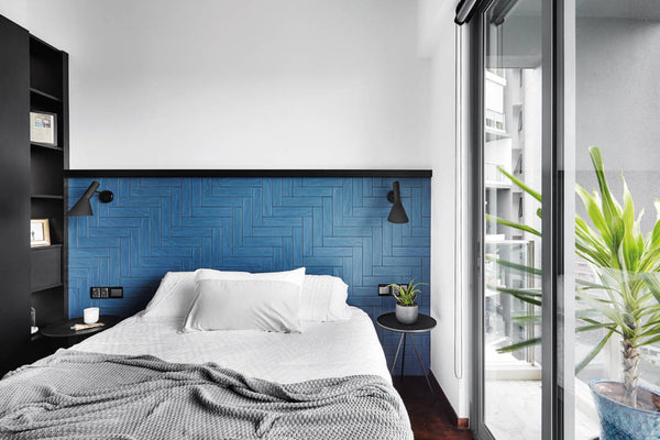 a bedroom with blue tiles at the head board