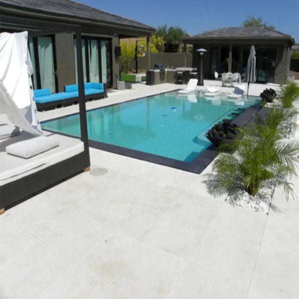 outdoor swimming pool area with light beige natural stone paver.