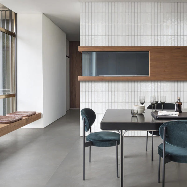 a living room with grey flooring tiles and white ceramic tiles on the walls