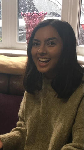 Smiling women with brown hair wearing camel coloured jumper.