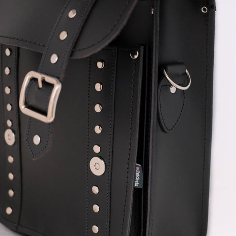 close up of magnetic fastenings on black studded backpack