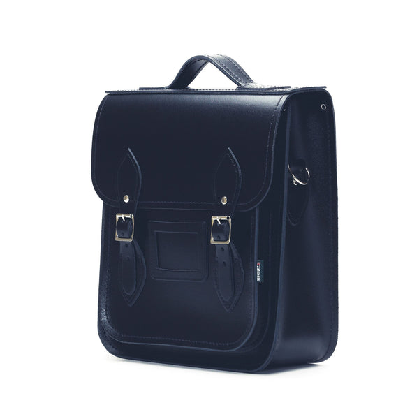 side view of black leather satchel backpack on a white background