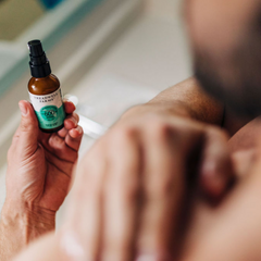 man rubbing CBD lotion into shoulder