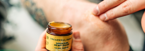 a person rubbing cbd salve onto their knee