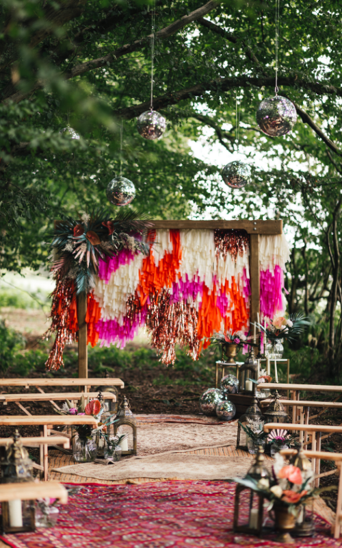 Woodland Wedding Ceremony - Tassled Backdrop - Bright and Colourful Wedding - Bright and Colourful Woodland Wedding Ideas - Tipi Wedding Inspiration