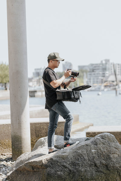 Photographer removes camera from top shelf bag