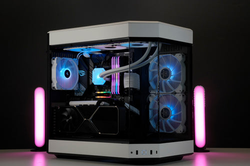 A fully custom build PC by Utopia. Based on the Hyte Y60 case in Snow White. The PC is photoed on a white desk with blue accent lighting.
