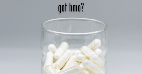 glass with white capsules inside and text above reading "got hmo?"