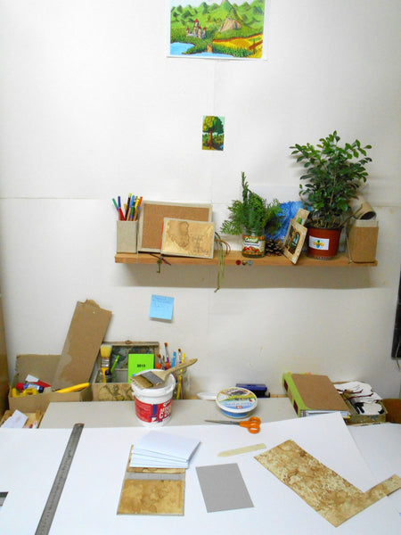 Workshop desk of a craftsman Hristo Hvoynev with handmade coffee papers and handmade journals on it together with instruments