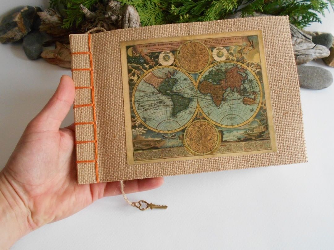 handmade sketchbook with burlap soft covers and a old world map fine print on the front cover and with Japanese stab binding with orange threads